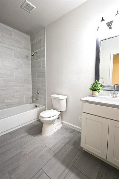 Bathroom featuring vanity, shower / tub combination, and wood finished floors