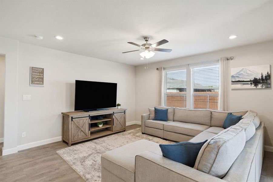 Living area with wood finished floors, recessed lighting, and a ceiling fan