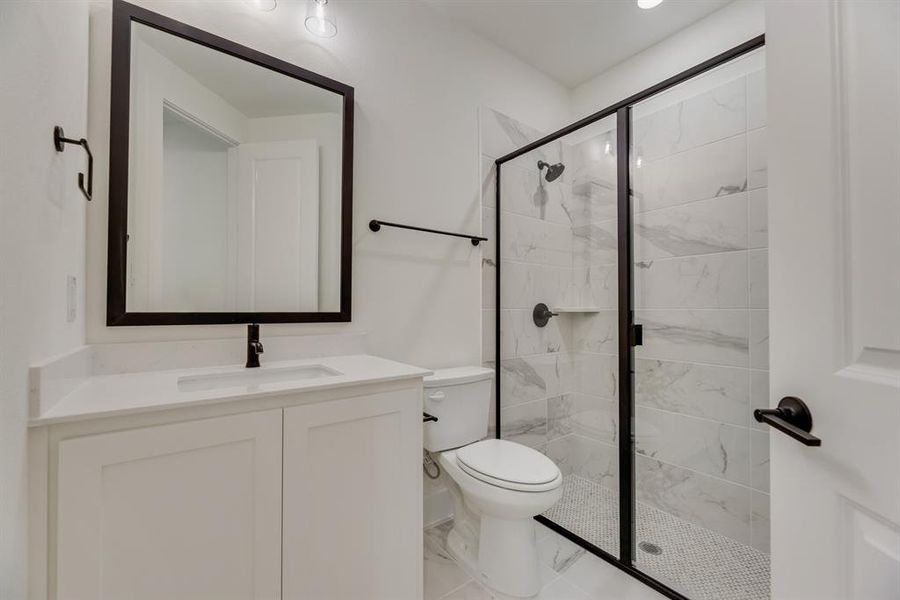 Bathroom featuring vanity and a marble finish shower Bathroom featuring vanity and a marble finish shower