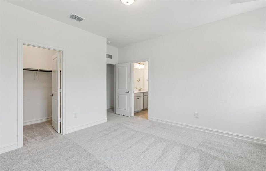 Roomy secondary bedroom with extensive closet storage  *Real home pictured