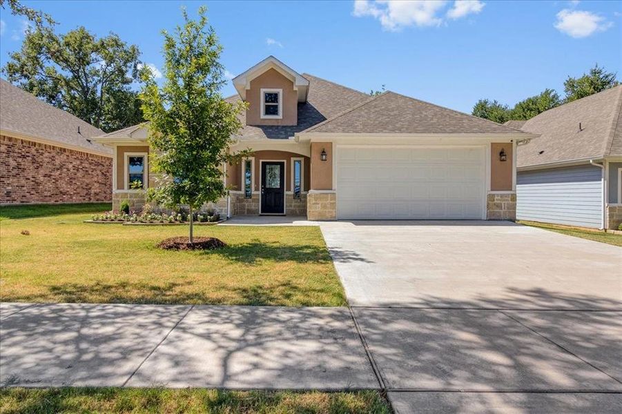 View of front facade with a garage and a front lawn