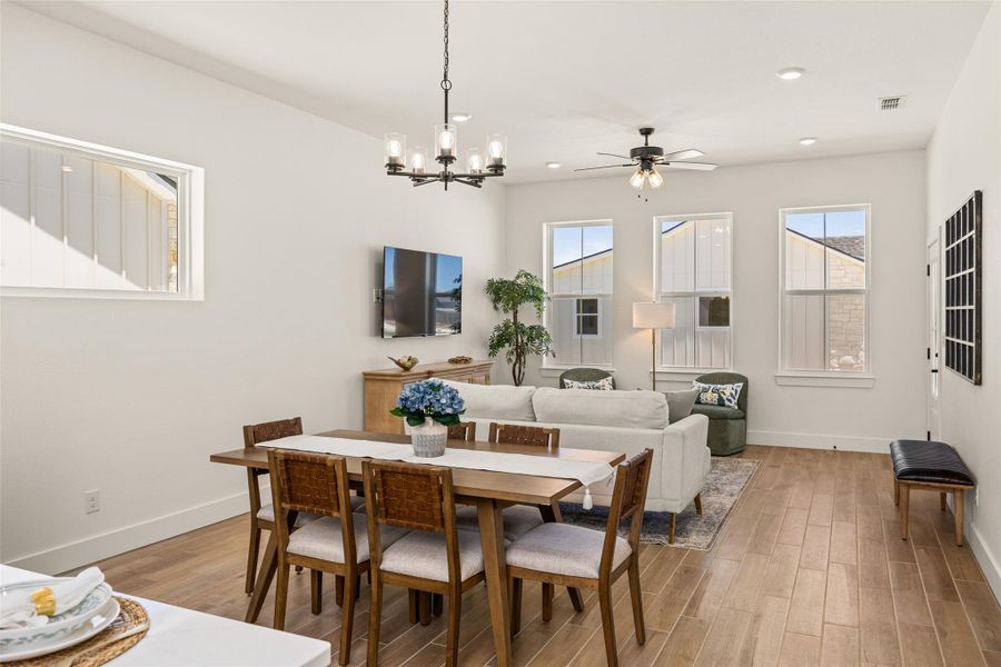 An open concept living and dining area boasts rich wood flooring and abundant natural light. An open concept living and dining area boasts rich wood flooring and abundant natural light.