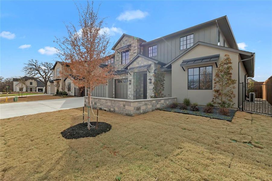View of front of home featuring a front lawn, driveway, board and batten siding, a gate, and a garage View of front of home featuring a front lawn, driveway, board and batten siding, a gate, and a garage