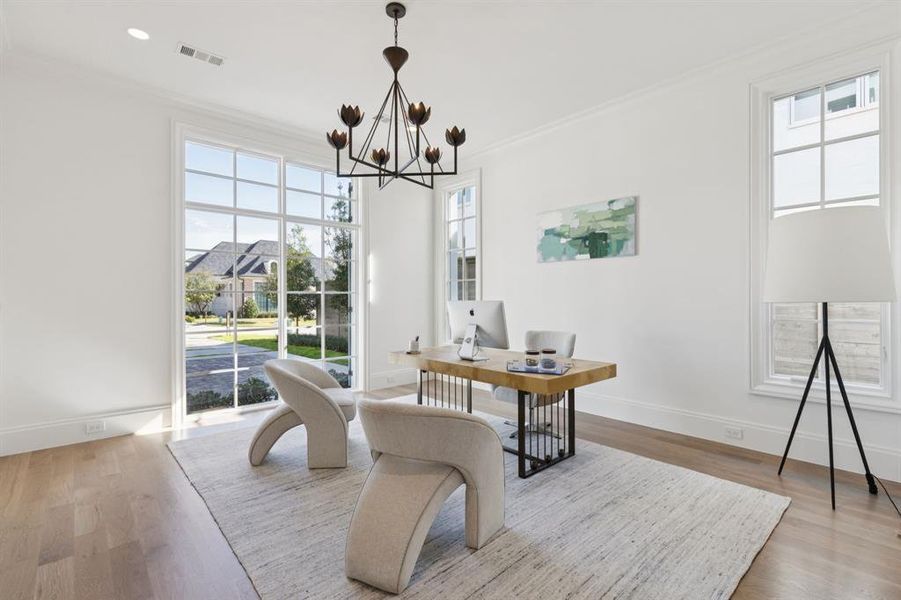 Home office featuring crown molding, wood finished floors, and a chandelier