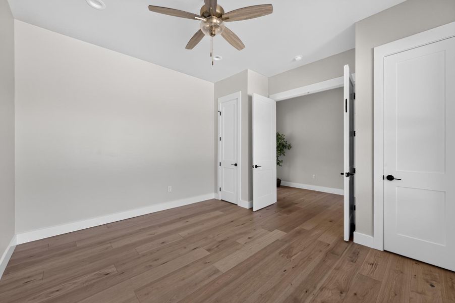 Smooth plaster walls and wide-plank wood flooring create a minimalist aesthetic in this versatile room.