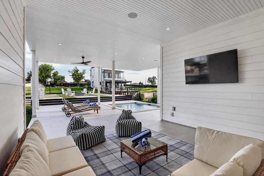 An inviting outdoor living space seamlessly connects to a refreshing pool and manicured lawn. An inviting outdoor living space seamlessly connects to a refreshing pool and manicured lawn.