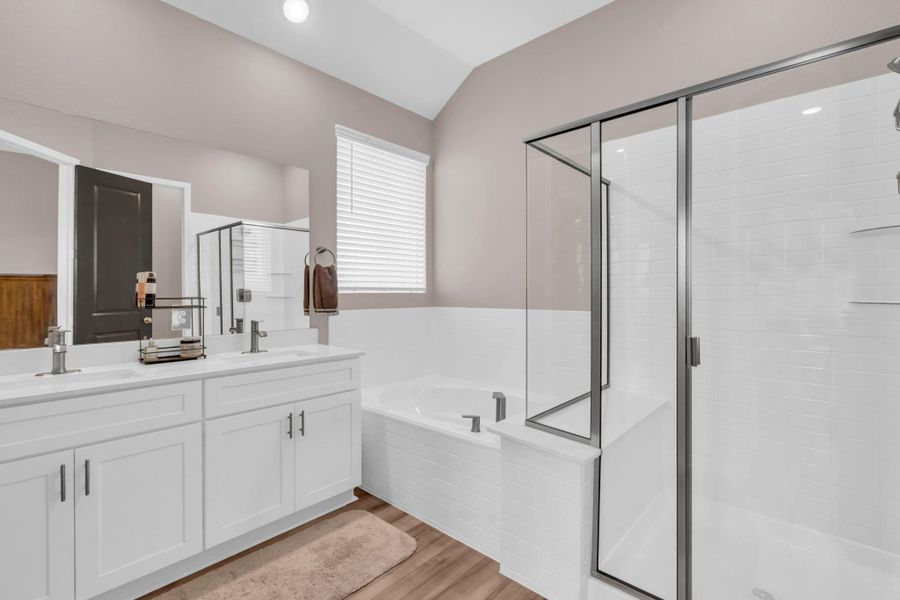 A double vanity, soaking tub with privacy window, and separate glass/tile shower make this the perfect primary bath. A double vanity, soaking tub with privacy window, and separate glass/tile shower make this the perfect primary bath.