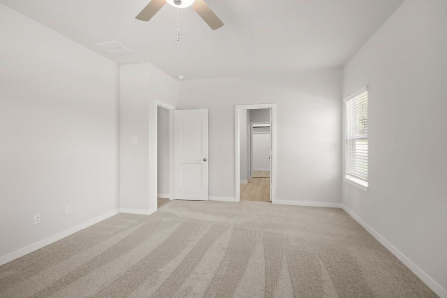 A room with a ceiling fan and a door. A room with a ceiling fan and a door.