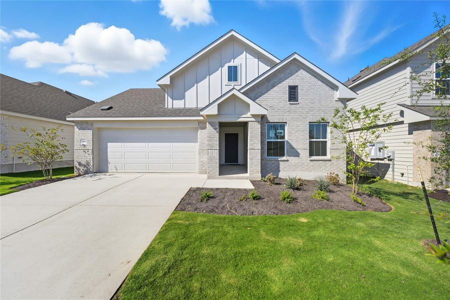 View of front of house with board and batten siding, brick siding, a front lawn, driveway, and an attached garage View of front of house with board and batten siding, brick siding, a front lawn, driveway, and an attached garage