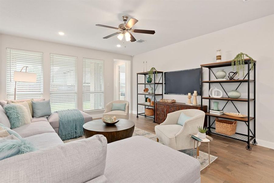 Living room featuring ceiling fan, light hardwood floors and views of the covered patio and backyard