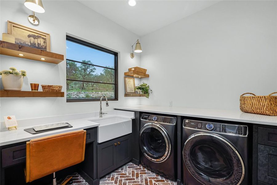 Laundry room featuring independent washer and dryer and sink