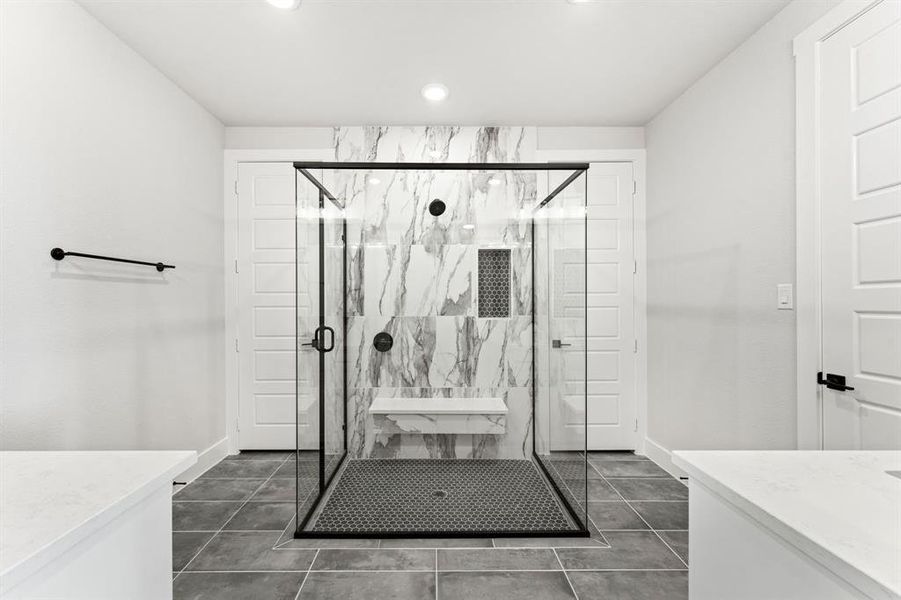 Bathroom with tile patterned floors, a shower with door, and vanity