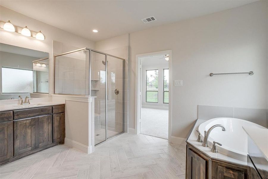 Bathroom featuring vanity, parquet flooring, and separate shower and tub