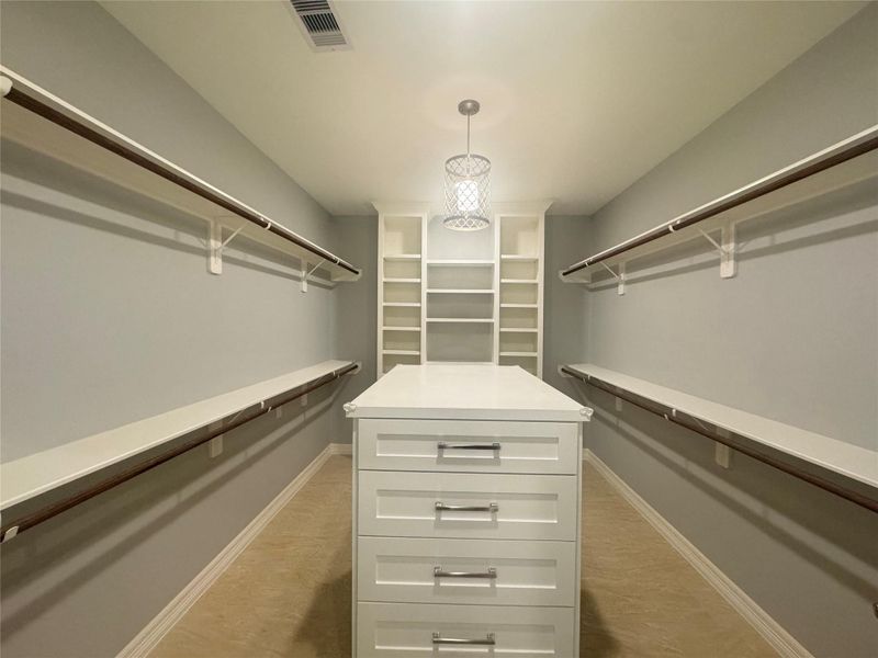 Huge walk-in closet with plenty of shelving and cabinets