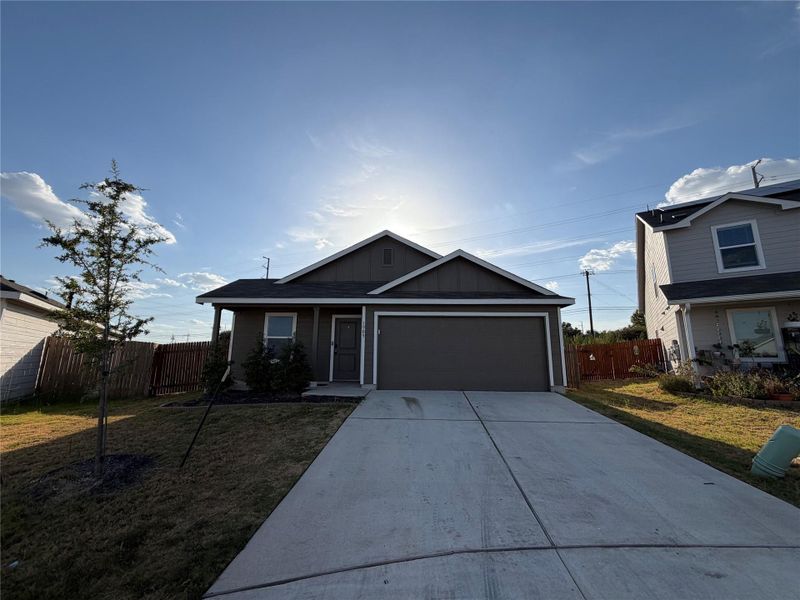 A concrete driveway leads to a classic garage and simple covered entryway.