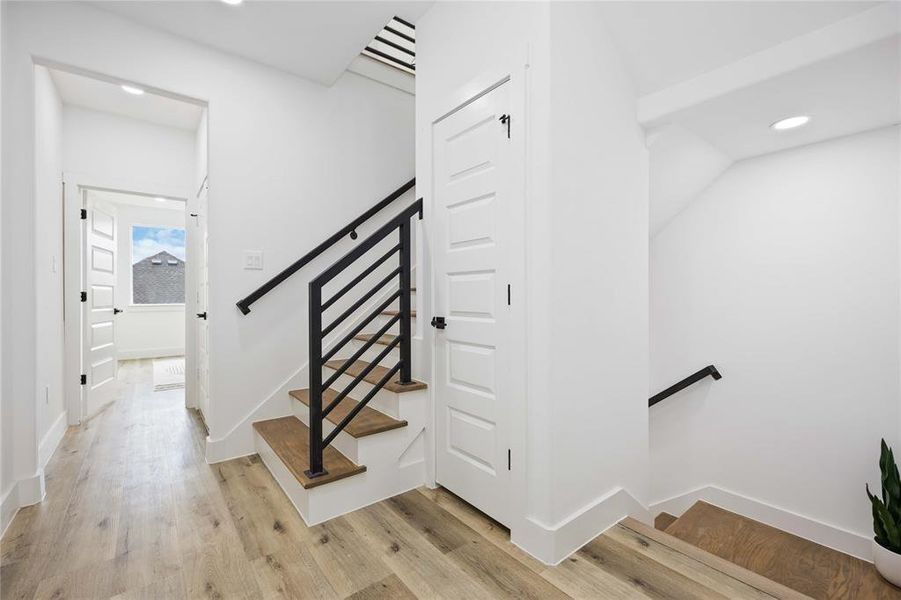The second floor includes the primary suite with two closets, an oversized secondary bedroom with a full ensuite bath, and a utility closet. The door to the right provides additional storage for this floor.