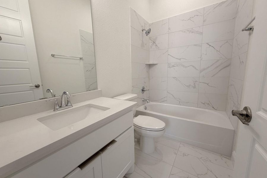 Full bathroom featuring vanity, light marble finish floors, and bathtub / shower combination