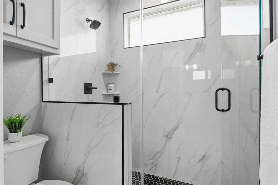 Bathroom with toilet and a marble finish shower