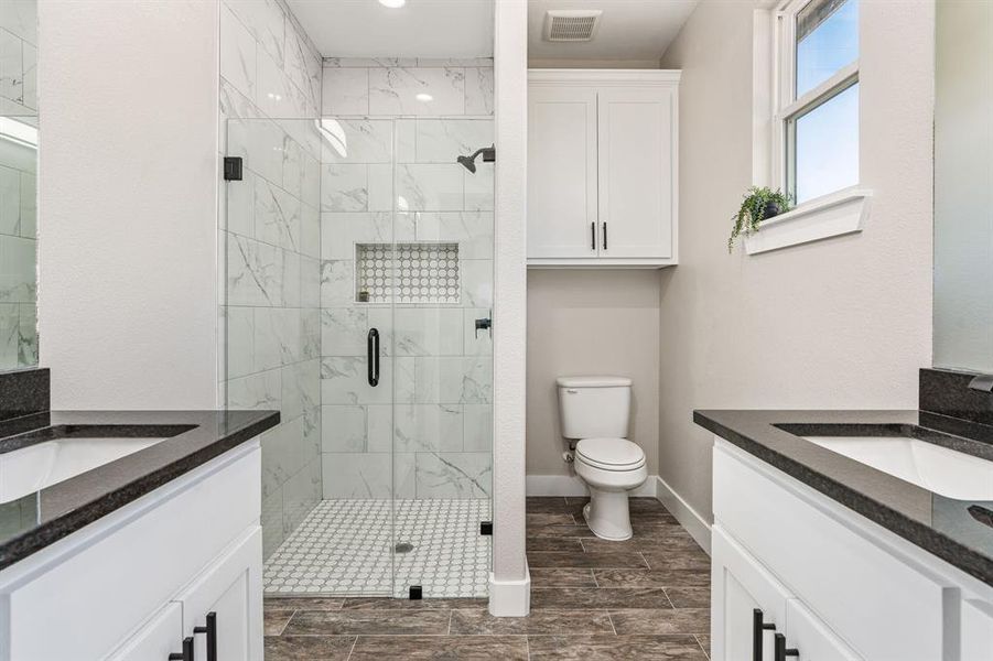 Bathroom with walk in shower, vanity, and toilet