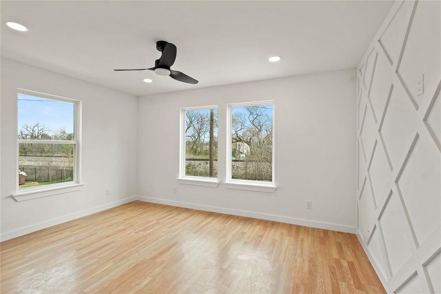 Unfurnished bedroom featuring multiple windows, ceiling fan, and light hardwood / wood-style floors