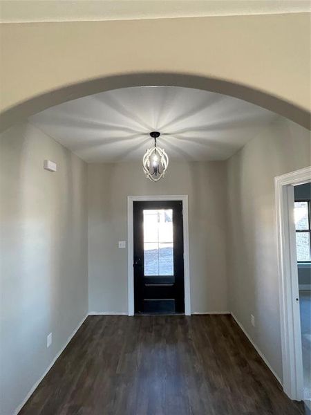 Foyer with dark hardwood / wood-style flooring and an inviting chandelier