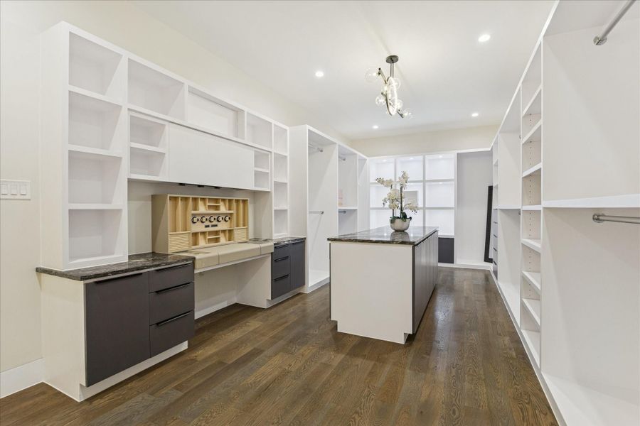 Spacious primary closet with elegant cabinetry, ample storage, and a stylish center island—your perfect wardrobe retreat.