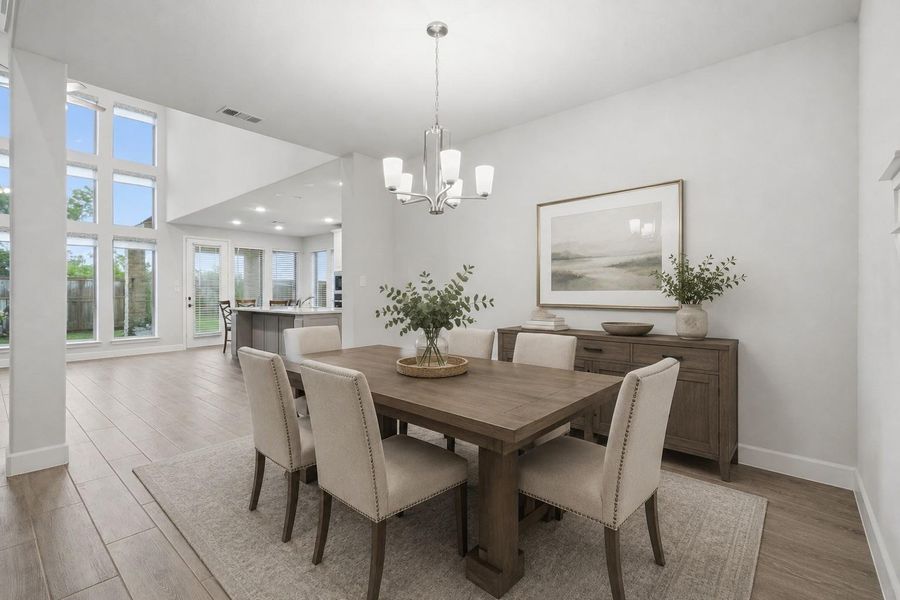 This photo showcases a bright virtually staged dining area with a modern chandelier. The open layout flows into a spacious living area with large windows, providing ample natural light. Neutral tones and minimalist decor create a warm, inviting atmosphere. This photo showcases a bright virtually staged dining area with a modern chandelier. The open layout flows into a spacious living area with large windows, providing ample natural light. Neutral tones and minimalist decor create a warm, inviting atmosphere.