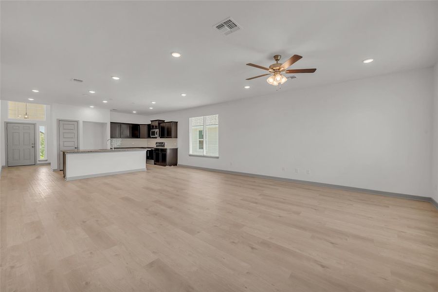 Unfurnished living room with light wood-type flooring, recessed lighting, and a ceiling fan