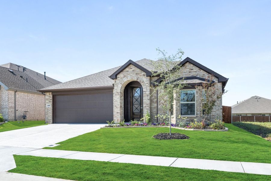 Single-story brick home with arched entry, two-car garage, and landscaped front yard
