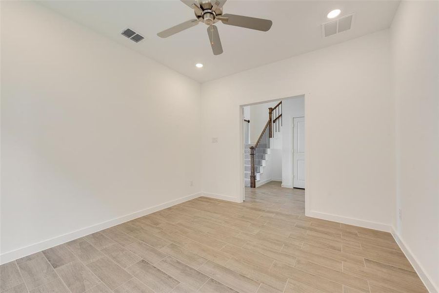 Empty room with ceiling fan and light hardwood / wood-style flooring