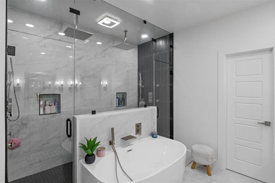 Bathroom featuring a soaking tub and a marble finish shower Bathroom featuring a soaking tub and a marble finish shower