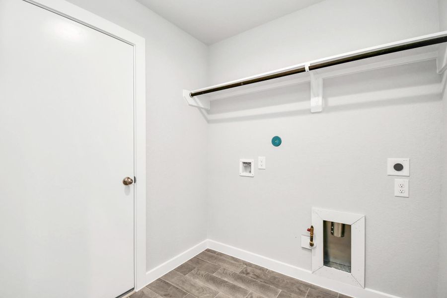 A perfect blend of functionality and comfort. Laundry room, thoughtfully equipped with shelving for effortless organization. Both gas and electric connections available.