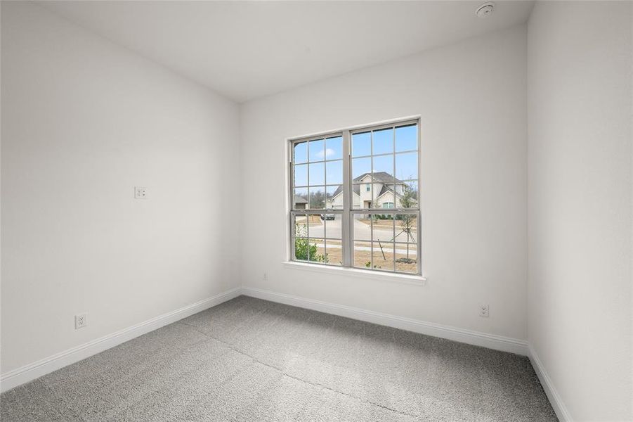 Spare room with carpet flooring, baseboards, and a smoke detector Spare room with carpet flooring, baseboards, and a smoke detector