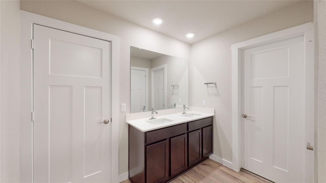 Double vanity and a spacious mirror create a functional and aesthetically pleasing bathroom environment. Double vanity and a spacious mirror create a functional and aesthetically pleasing bathroom environment.
