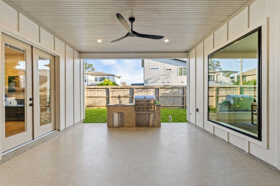 Weekend cookouts become effortless with your covered patio featuring a built-in outdoor kitchen, ceiling fan, and plenty of space to relax year-round.