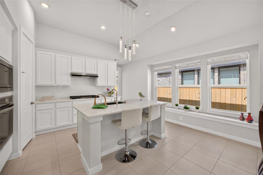 Bright, open kitchen with a charming window seat. Bright, open kitchen with a charming window seat.