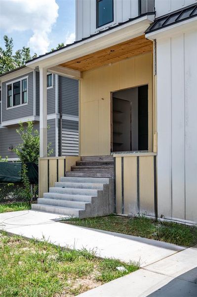 Stunning front elevation with vertical board and batten and German smear brick stairs and landing leading to your custom white oak french front door.