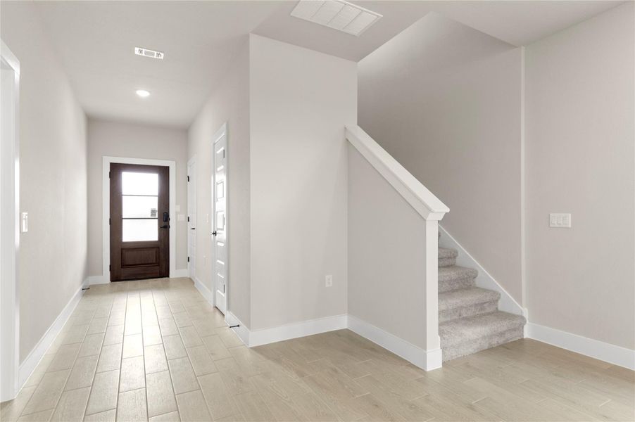 Foyer entrance with light wood-style flooring, stairs, baseboards, and recessed lighting Foyer entrance with light wood-style flooring, stairs, baseboards, and recessed lighting