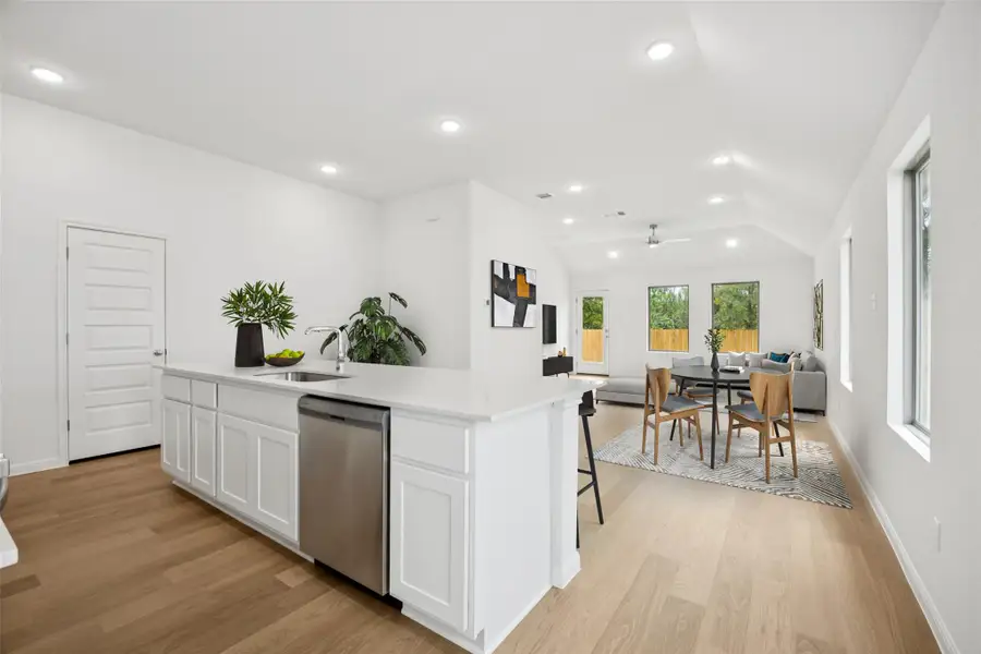 Kitchen featuring open floor plan, light wood-type flooring, dishwasher, white cabinetry, and recessed lighting Kitchen featuring open floor plan, light wood-type flooring, dishwasher, white cabinetry, and recessed lighting