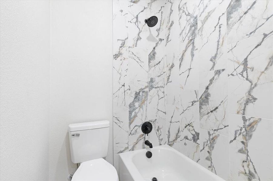 Bathroom featuring toilet and tiled shower / bath