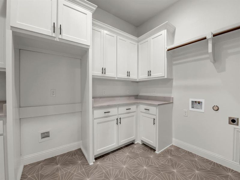 Laundry area featuring cabinets, washer hookup, light tile patterned floors, and electric dryer hookup