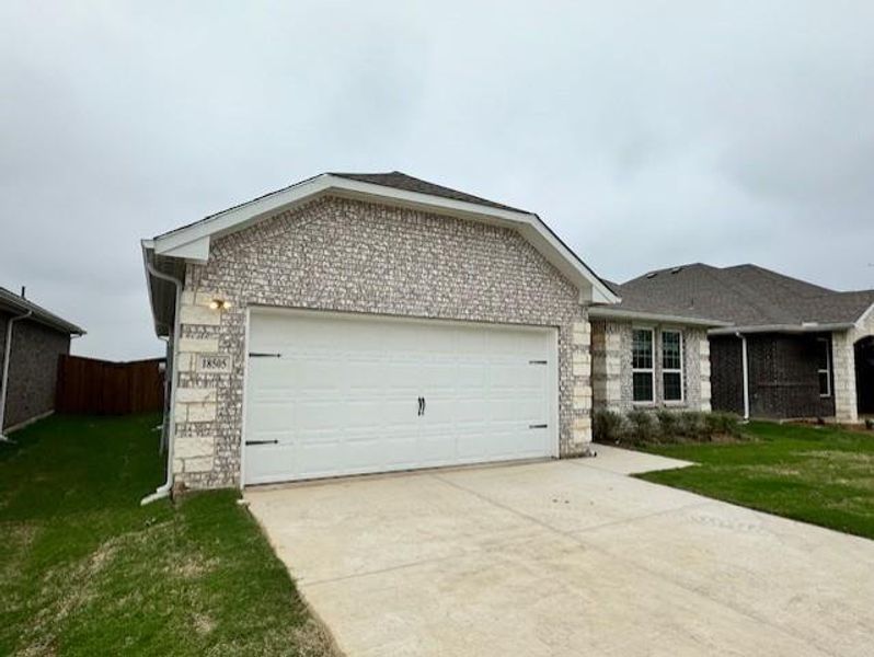 Single story home with concrete driveway, a garage, and stone siding Single story home with concrete driveway, a garage, and stone siding