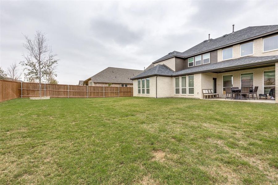 Rear view of house featuring a yard and a patio