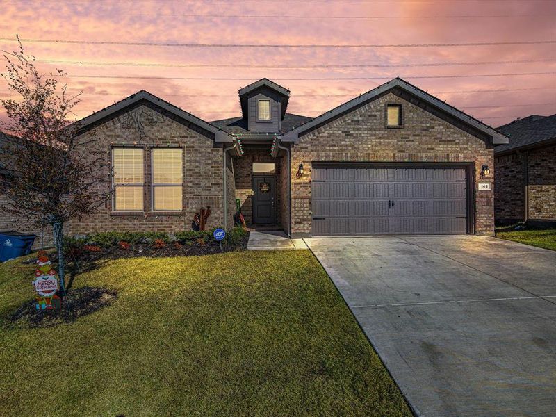 View of front of property with a lawn and a garage