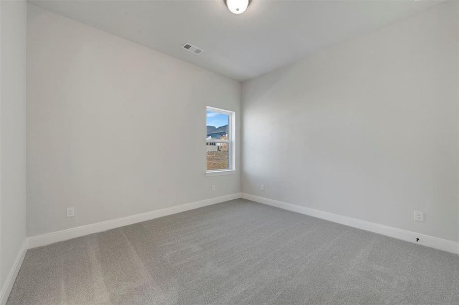Spare room featuring light colored carpet and baseboards