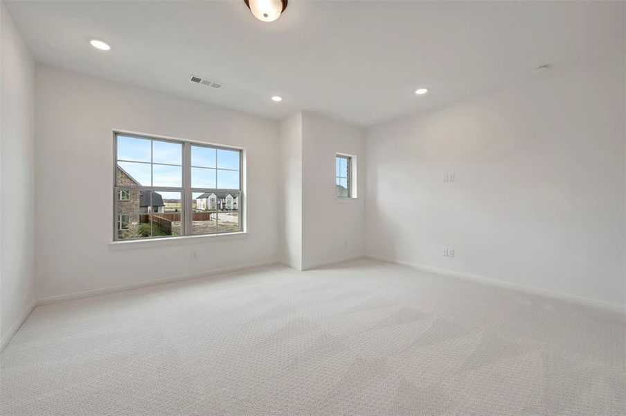 Empty room with recessed lighting and light carpet