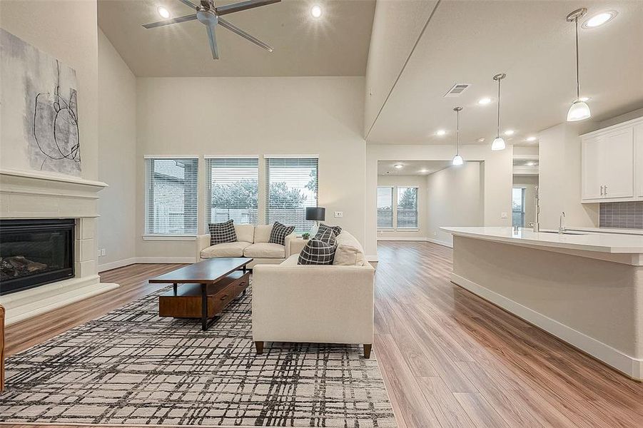 The family room exudes spaciousness with its high ceiling and wall of windows to bring in natural light.