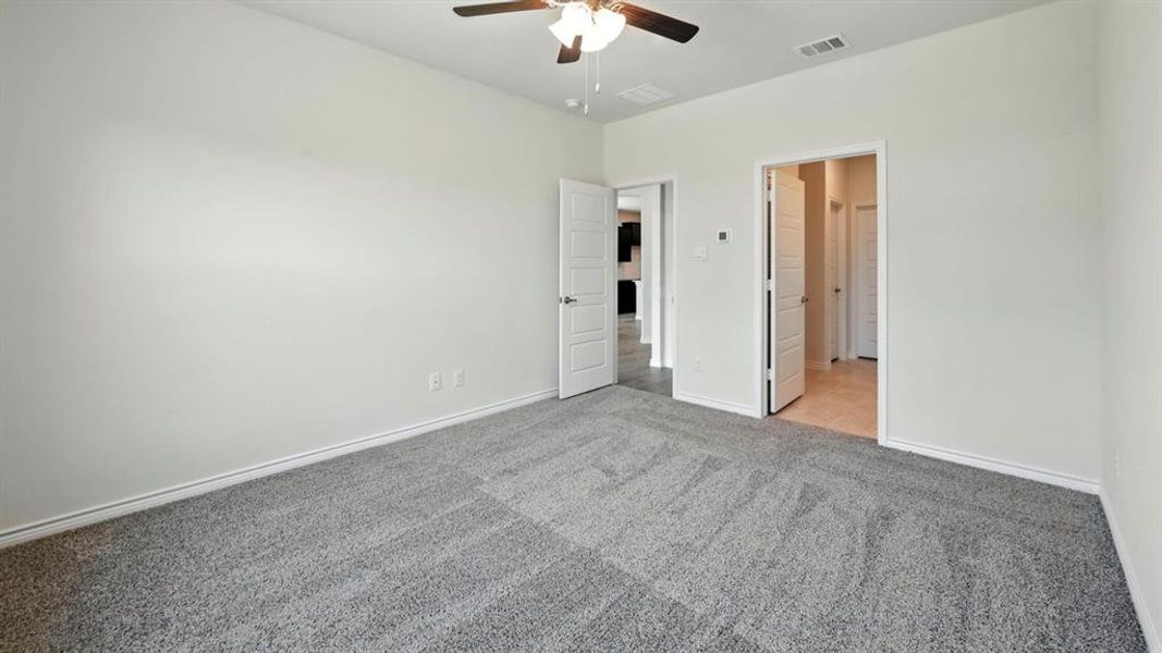 Unfurnished bedroom with light carpet and a ceiling fan