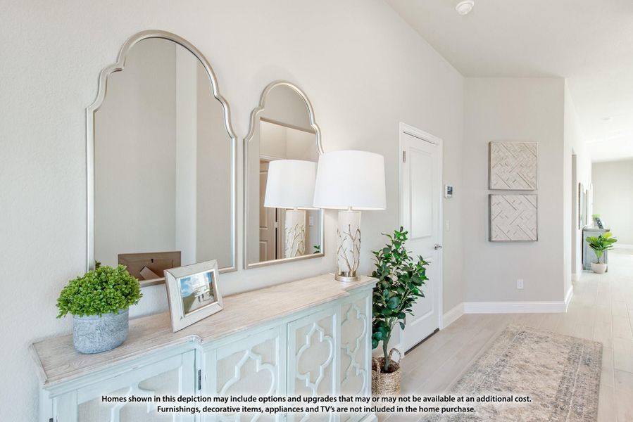 Entryway hallway with decorative console table, arched mirrors, and light wood floors Entryway hallway with decorative console table, arched mirrors, and light wood floors