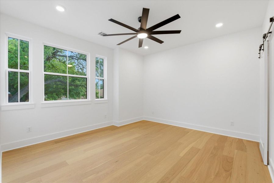 One of the three spacious upstairs bedrooms, filled with natural light and complete with recessed lighting and a ceiling fan.